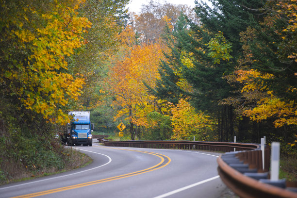 蓝色卡车在壮观的蜿蜒的秋季公路上图片下载