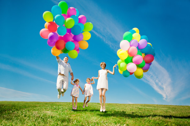 快乐的一家人在户外举着五颜六色的气球。妈妈，ded和2图片下载