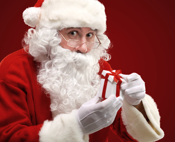 快乐的圣诞老人看着白色的礼盒图片下载