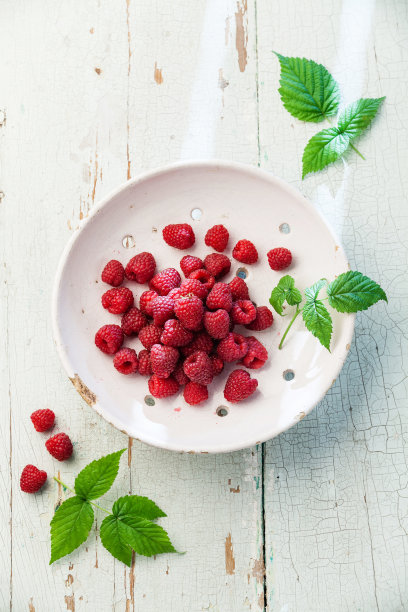 古董陶瓷滤锅中的覆盆子图片下载