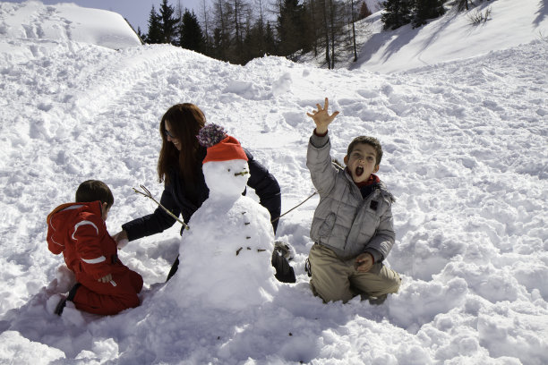 两个兄弟和妈妈一起堆雪人图片下载