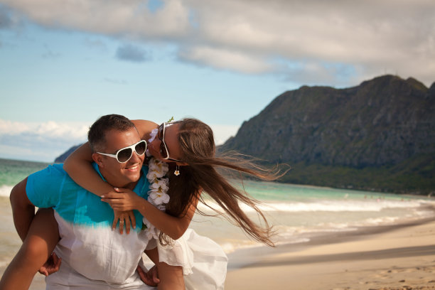 幸福的年轻夫妇在海滩上玩得很开心图片下载