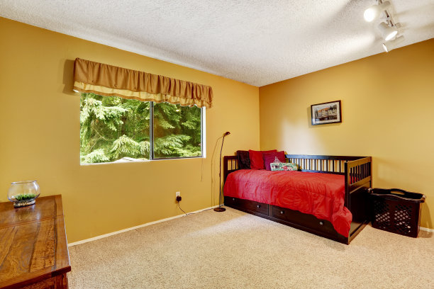 明亮的黄色卧室配有黑色的木床图片下载