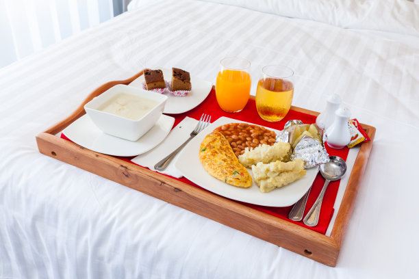 早餐装在木托盘里，摆在床上图片下载