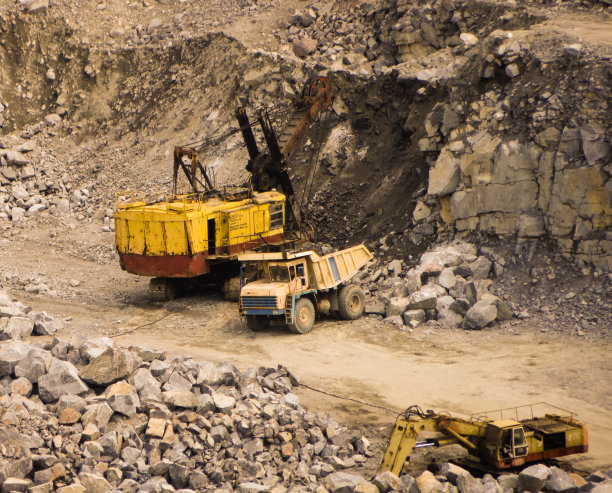 挖掘机把石头装到自卸卡车上图片下载