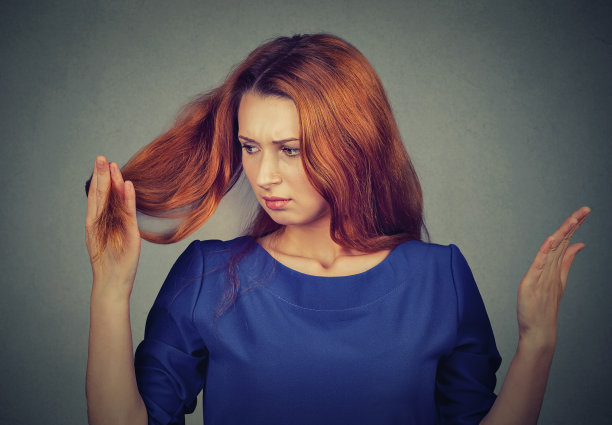 沮丧沮丧的女人失去头发注意到分叉图片下载