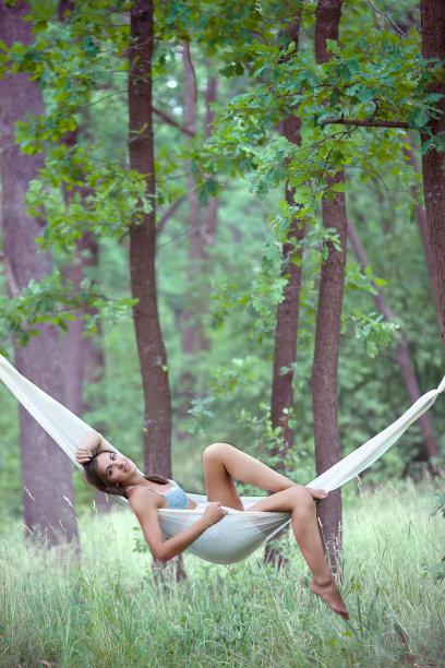 一个年轻女子躺在度假胜地的吊床上图片下载