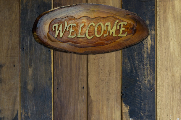 欢迎标志标签上的复古木材背景。图片下载