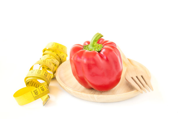 黄色卷尺和甜红辣椒在木盘里图片下载