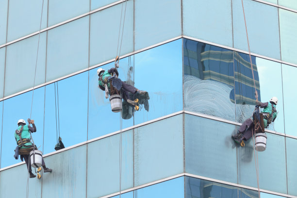 在高层建筑上清洁窗户的工人图片下载