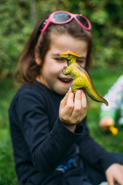 小女孩在玩恐龙橡胶玩具图片下载