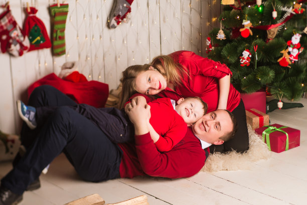 年轻的怀孕的母亲，父亲和年幼的儿子在庆祝圣诞节图片下载