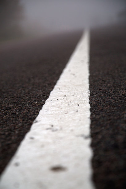 中央条纹柏油路在秋天的雾图片下载