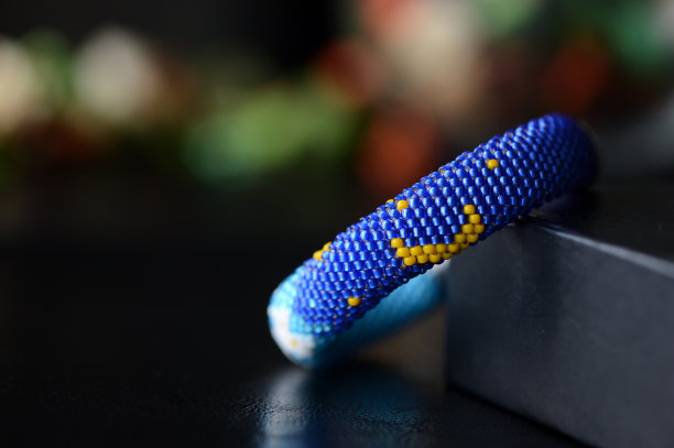 串珠手镯白色的猫和月亮在一个黑暗的背景图片下载