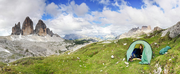 女人坐在帐篷里笑得很开心。伟大的山脉。混乱关系总会。图片下载