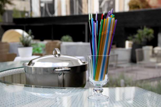 吧台桌上的鸡尾酒杯中的彩色鸡尾酒吸管图片下载