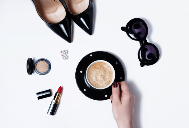 女性手握咖啡杯和女性配件。近距离素材图片