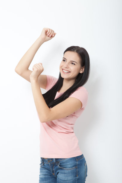 快乐的年轻女子在白色背景上跳舞的肖像图片下载