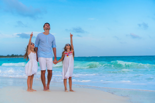 日落时分，父亲和孩子们在海滩上图片下载