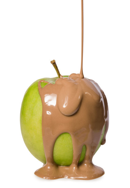 绿色苹果覆盖着流动的牛奶巧克力孤立在白色的背景图片下载