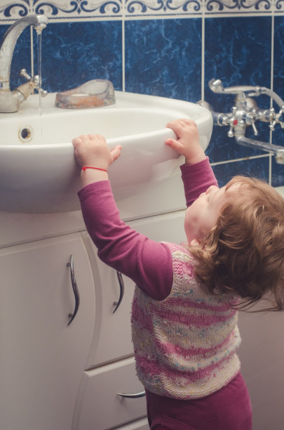 小女孩伸手去拿浴室里的水槽图片下载