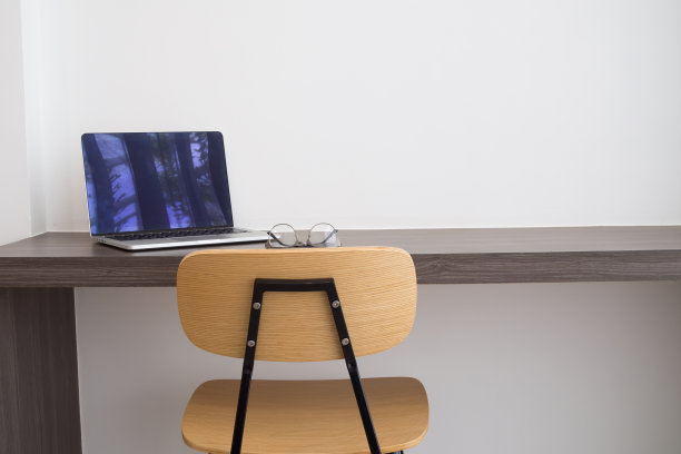 办公室桌子白色笔记本电脑，现代椅子和现代眼镜。图片下载