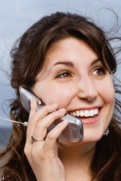 年轻女子用手机，微笑，特写图片下载