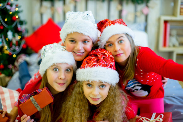 一群戴着红帽子拿着圣诞礼物的孩子图片下载