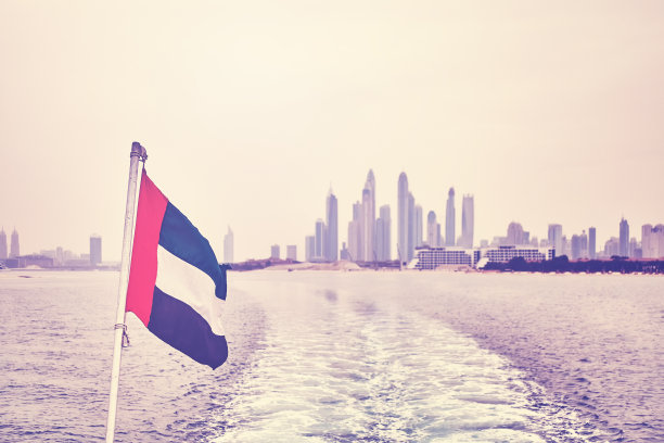 复古风格的阿拉伯联合酋长国国旗与迪拜的地平线在远处。图片下载