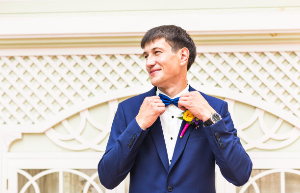 在户外，男人的手触到了西装领结图片下载