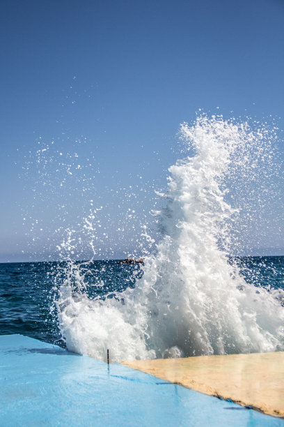 在多风的天气里，海浪拍打着混凝土码头。图片下载