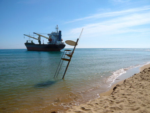 一艘船在西班牙瓦伦西亚的塞勒海滩搁浅。集装箱船搁浅后。巴拿马货船Bsle Sunrise在大风风暴后搁浅。黑色和红色的船在灾难后。2012图片下载