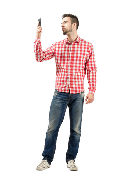 穿格子衬衫的男人在看他的智能手机图片下载