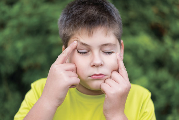 男孩在夏天的公园里做鬼脸图片下载