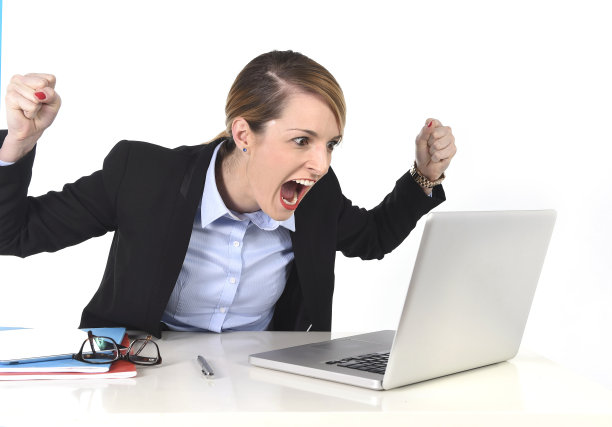 忙碌的女商人兴奋地在桌上的电脑笔记本电脑工作图片下载