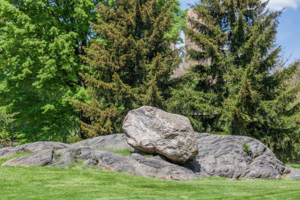 美国纽约，中央公园休闲区，天然岩石装饰，以绿色森林为背景。图片下载