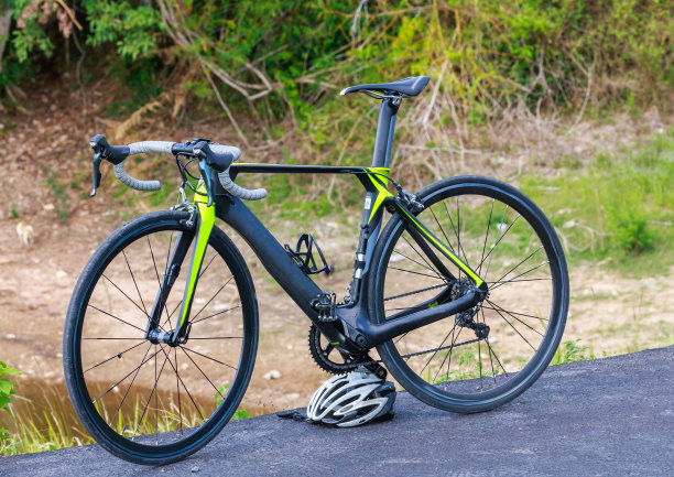 三轮车交叉戴着头盔，站在水库附近的道路上图片下载