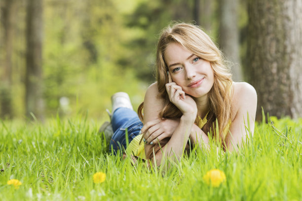 女人躺在蒲公英地里图片下载