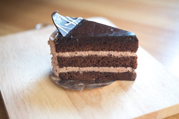 木桌上放着巧克力奶油蛋糕图片下载