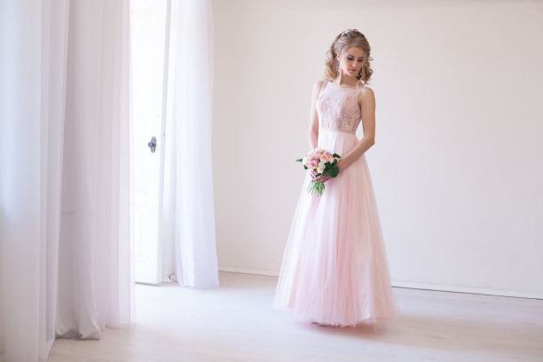 新娘身着粉色婚纱，捧着一束鲜花图片下载