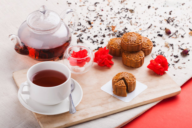 中国中秋节美食：摆放在桌上的传统月饼和茶杯素材图片