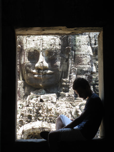 年轻男子在柬埔寨雕像前休息图片下载