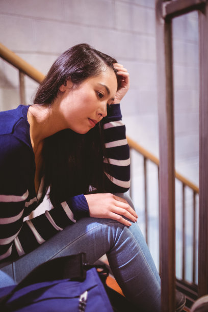 焦虑的学生坐在走廊里图片下载