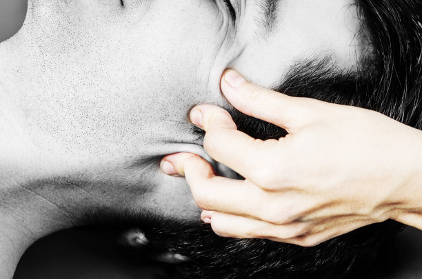 理疗师在白色背景上的剪影工作室里对一名男性病人进行颅骶疗法。图片下载