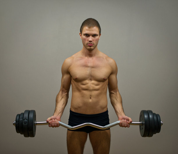 肌肉男模练杠铃。图片下载
