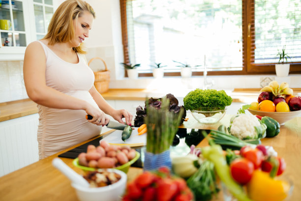 美丽的孕妇正在用新鲜的食材做饭图片下载