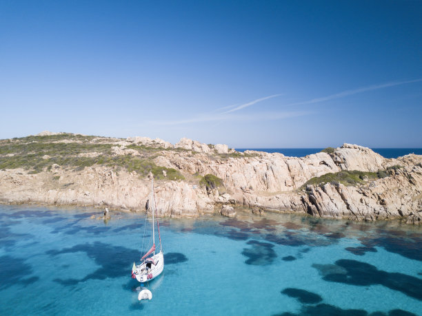 撒丁岛莫里托里奥岛前一艘帆船的鸟瞰图。令人惊叹的海滩，绿松石和透明的大海。翡翠海岸，撒丁岛，意大利图片下载