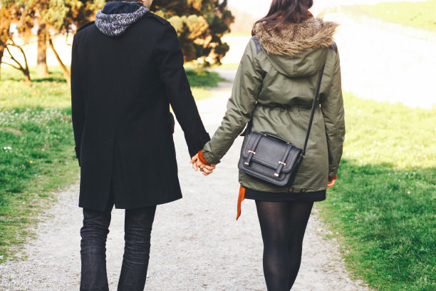 后视图的年轻夫妇牵着手图片下载
