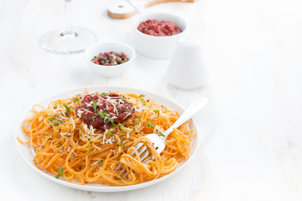 白色的木桌上放着番茄酱意大利面和帕尔马干酪图片下载