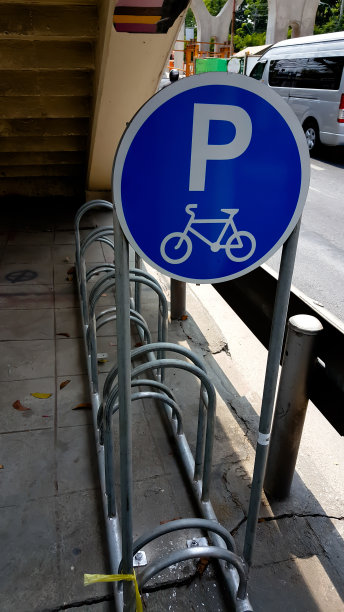 空的户外自行车停车场和自行车标志在砖墙上图片下载